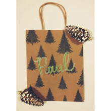 Load image into Gallery viewer, Would you like a personalized kraft bag for a holiday gift for a loved one? This tree gift bag is a classic one to give this holiday season. Each gift bag can be personalized with a name written in calligraphy with choice of font colour. Medium kraft bag dimensions 8 x 10 inches (20.3 cm x 25.4 cm)