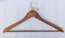 Load image into Gallery viewer, This custom hanger will hold your beautiful wedding dress on your special day. Wood hangers are hand-lettered with the bride's name and your wedding date. "bride" is written in calligraphy on the centre of the hanger, and the bride's name and your wedding date in block lettering with your choice of gold or chrome font colour.
