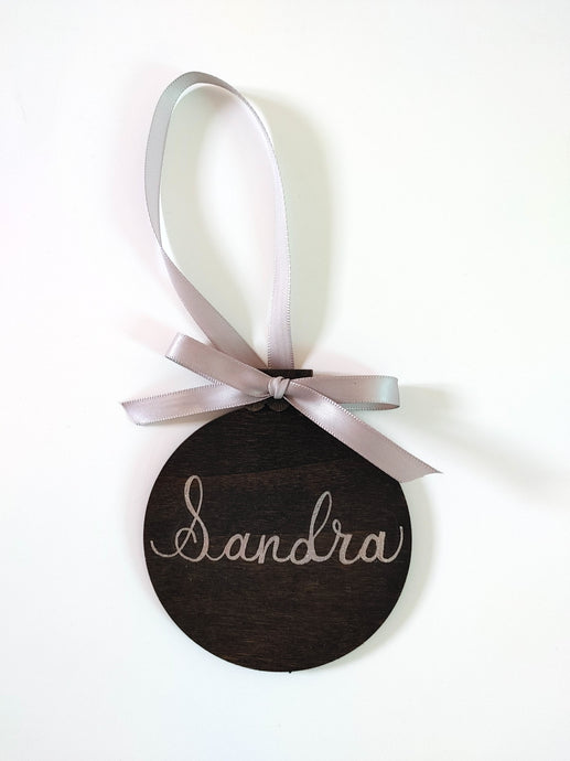 Wood ornaments are stained your choice of colour, and can be personalized in your choice of font colour.  Each ornament has a ribbon tied in a bow included.  Baltic Birch 4 inch round, 3mm thick.
