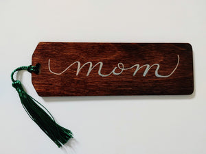 Do you have a book lover in your life?   Each bookmark is stained your choice of colour, and can be personalized in your choice of font colour. Each bookmark has a colourful tassel included.   Baltic Birch 2x6 inches, 3mm thick This espresso stained bookmark in a rectangular shape has a beveled edge. "mom" is written in calligraphy and silver font. 