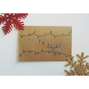 This holiday Christmas card "merry & bright is accented with colorful Christmas lights that have chrome accents, and is writtend in black calligraphy font. It is completely hand drawn with "merry and bright" written in calligraphy.  Envelope is included.   9x6inches 