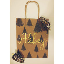 Load image into Gallery viewer, Would you like a personalized kraft bag for a holiday gift for a loved one? This tree gift bag is a classic one to give this holiday season.   Each gift bag can be personalized with a name written in calligraphy with choice of font colour.   Medium kraft bag dimensions 8 x 10 inches (20.3 cm x 25.4 cm)
