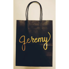 Load image into Gallery viewer, This classic black gift bag can be personalized with the name or saying of your choice.  Each gift bag is written in calligraphy in your choice of font colour.  Medium kraft bag dimensions: 8 x 10 inches (20.3cm x 25.4 cm) 
