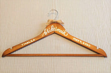 Load image into Gallery viewer, If you are looking for a perfect gift for your bridesmaid here is a custom hanger to accent her beautiful dress.  Wood hangers are hand-lettered with the bridesmaid&#39;s name and the wedding date. &quot;bridesmaid&quot; is written in calligraphy on the centre of the hanger, and the bridesmaid&#39;s name and your wedding date in block lettering with your choice of gold or chrome font colour.
