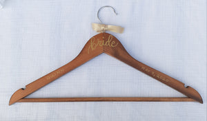 This custom hanger will hold your beautiful wedding dress on your special day.  Wood hangers are hand-lettered with the bride's name and your wedding date. "bride" is written in calligraphy on the centre of the hanger, and the bride's name and your wedding date in block lettering with your choice of gold or chrome font colour.