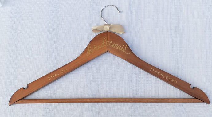 If you are looking for a perfect gift for your bridesmaid here is a custom hanger to accent her beautiful dress.  Wood hangers are hand-lettered with the bridesmaid's name and the wedding date. 