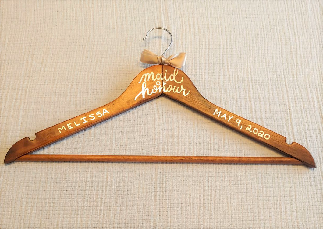 If you are looking for a perfect gift for your maid of honour here is a custom hanger to accent her beautiful dress.  Wood hangers are hand-lettered with the maid of honour’s name and the wedding date. 